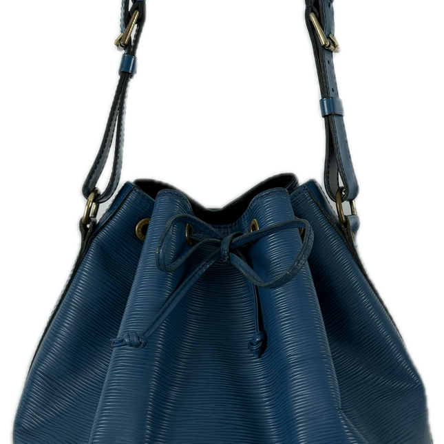 Blue Louis Vuitton Epi Noe GM Bucket Bag. The Noe GM features blue epi leather body, an adjustable leather shoulder strap, and an open top with a drawstring closure.